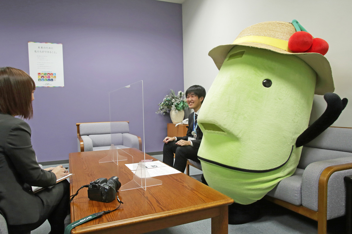 山形県DC推進監のきてけろくん(写真右)と山形県観光文化スポーツ部 観光立県推進課の安達元輝さん(写真・中央)。同じ課に勤務する2人は取材中も息がぴったり ※撮影時のみマスクを外していただいております